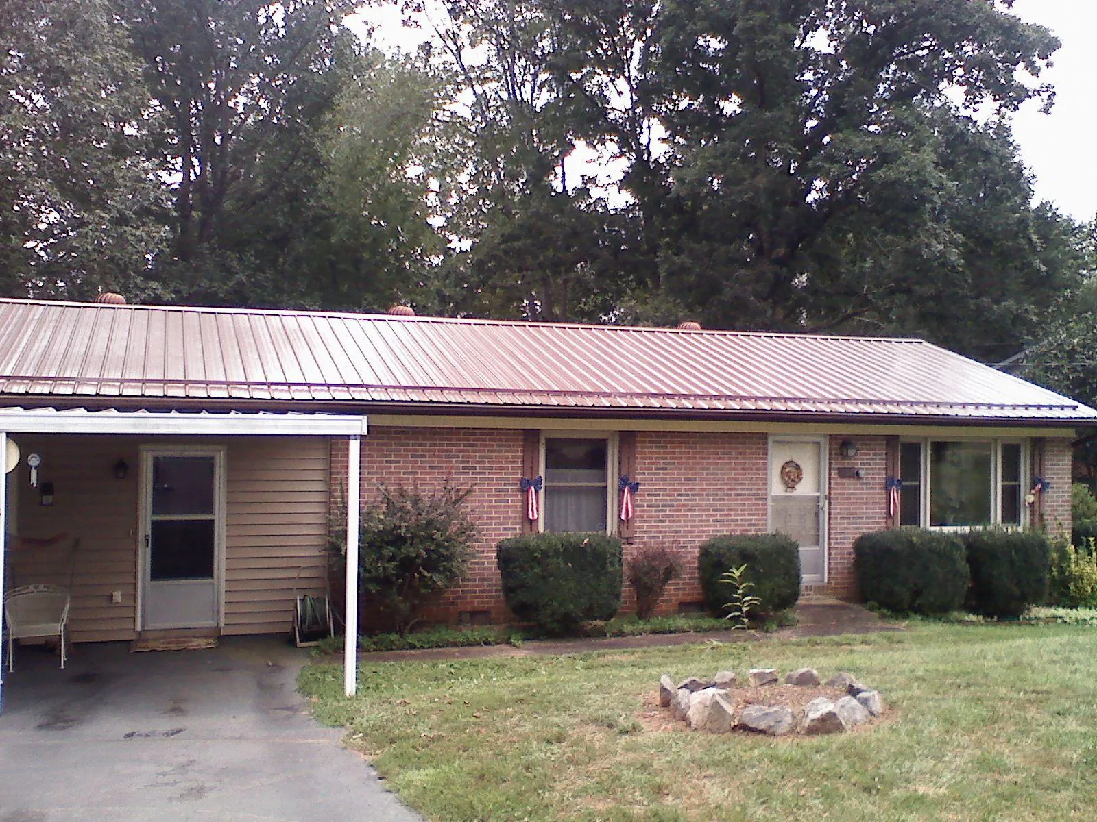 Bronze metal roof and carport on a brick ranch home — Roof Repair work by our crew in Moline